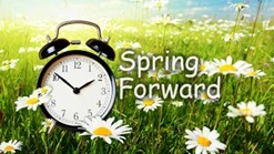 Spring Forward. An alarm clock in a field of flowers.