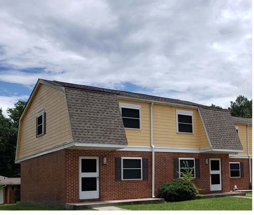 A view of a public housing unit with an irregular roof. 