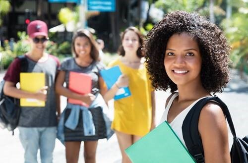 4 college students holding books