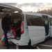 A man holding a bag by a van.