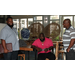 Three men in the lobby, two are standing and one is sitting a a table.