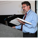 The Presenter standing at a podium speaking.