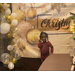 A girl poses in front of a Merry Christmas banner.
