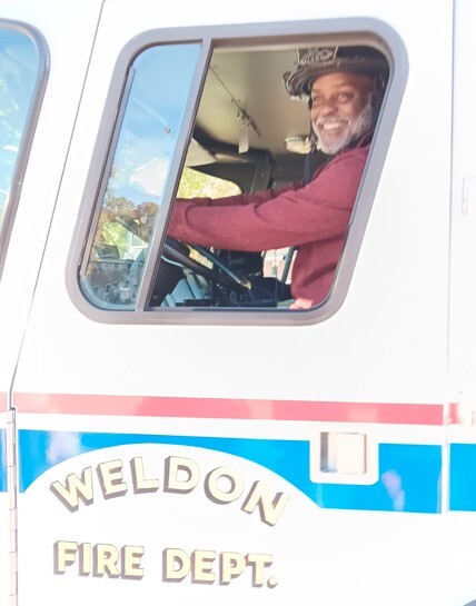AmandrivingaWeldonFireDepartmenttruck.jpg A man driving a Weldon Fire Department truck.