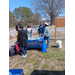 A group of people standing around a table outdoors.