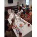  Three women sit around a table painting. 