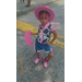  A young girl in a pink cowgirl outfit posing for a photo. 