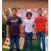  Three boys standing and smiling for a photo. 