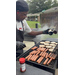  A man grills up hotdogs and hamburgers. 