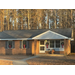  A brick house decorated with five Christmas wreaths. 