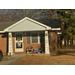  Front of a brick building that is decorated wtih sparkly tinsel, and wreaths. 